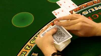 The dealer is hitting the players hand on a handheld deck The dealer is hitting the players hand on a handheld deck