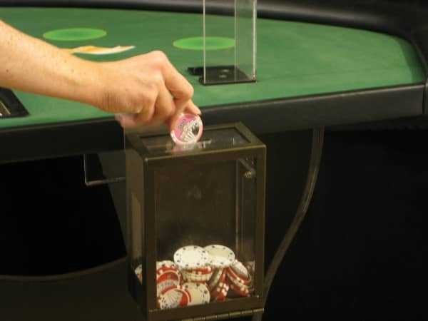 The dealer is putting chips in the toke box The dealer is putting chips in the toke box