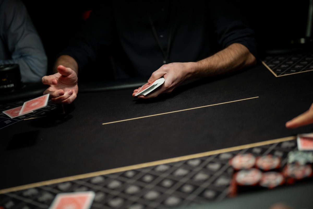 the dealer is pitching cards on a poker table