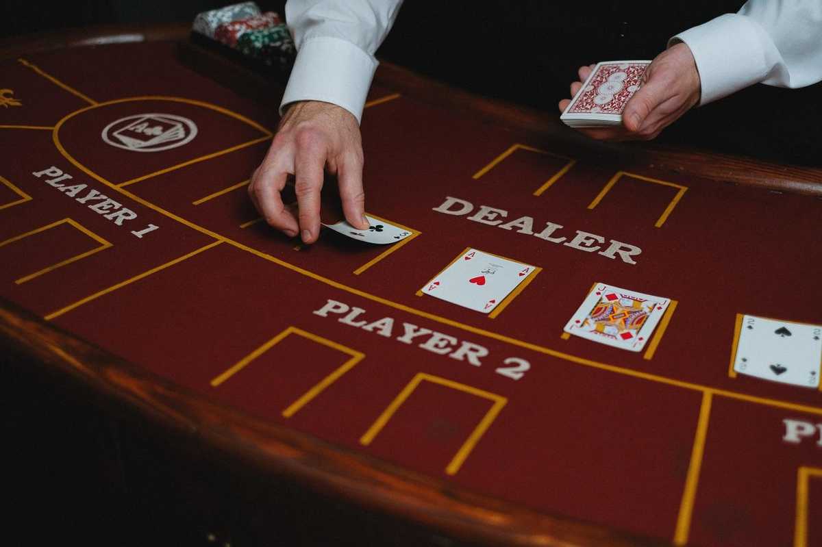 a dealer hand places a card on the table a dealer hand places a card on the table