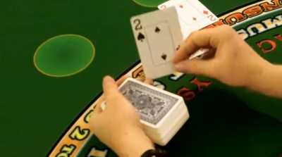 The dealer is hitting the players hand on a handheld deck The dealer is hitting the players hand on a handheld deck