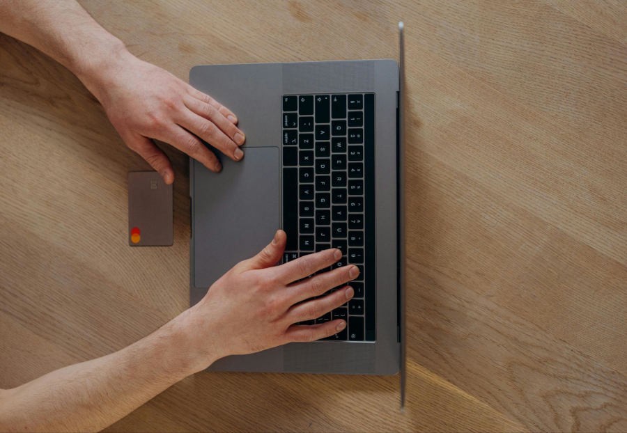 man using a laptop to pay with his credit card