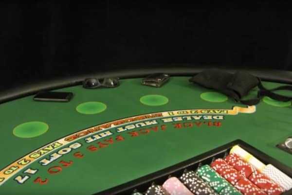 The blackjack table has sunglasses, a purse, a wallet and a phone on it The blackjack table has sunglasses, a purse, a wallet and a phone on it