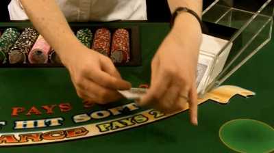 The dealer is taking the card out of the shoe The dealer is taking the card out of the shoe