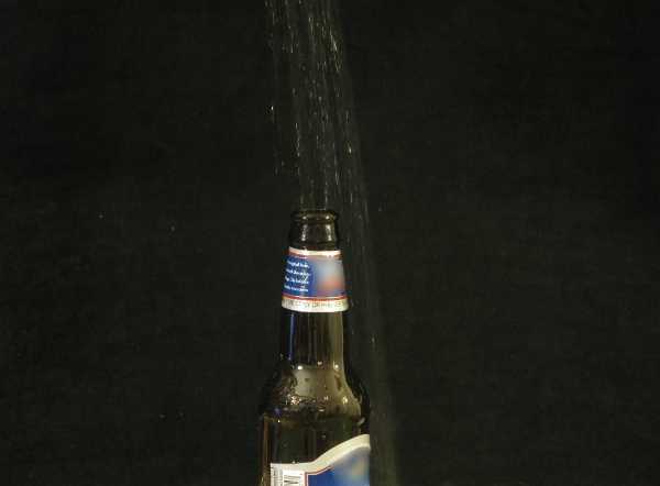 A beer bottle with liquid pouring in it A beer bottle with liquid pouring in it